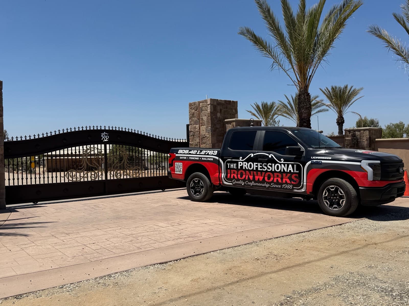 The Professional Ironworks truck beside a custom iron gate